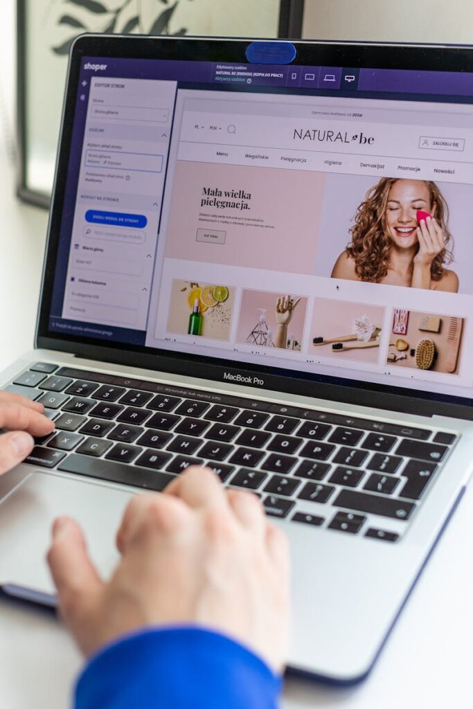 Hands typing on a laptop with an e-commerce website open, showcasing online shopping.
