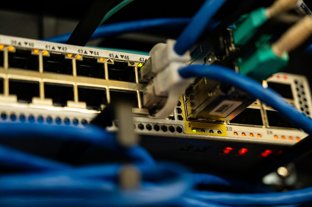 pexels-photo-2881224-2881224 Close-up image of ethernet cables plugged into a network switch, showcasing IT infrastructure.