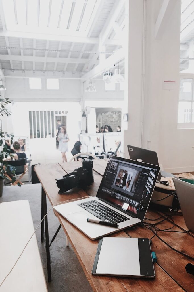pexels-photo-699459-699459 A bright, modern workspace featuring laptops, a camera, and a drawing tablet in an indoor office.
